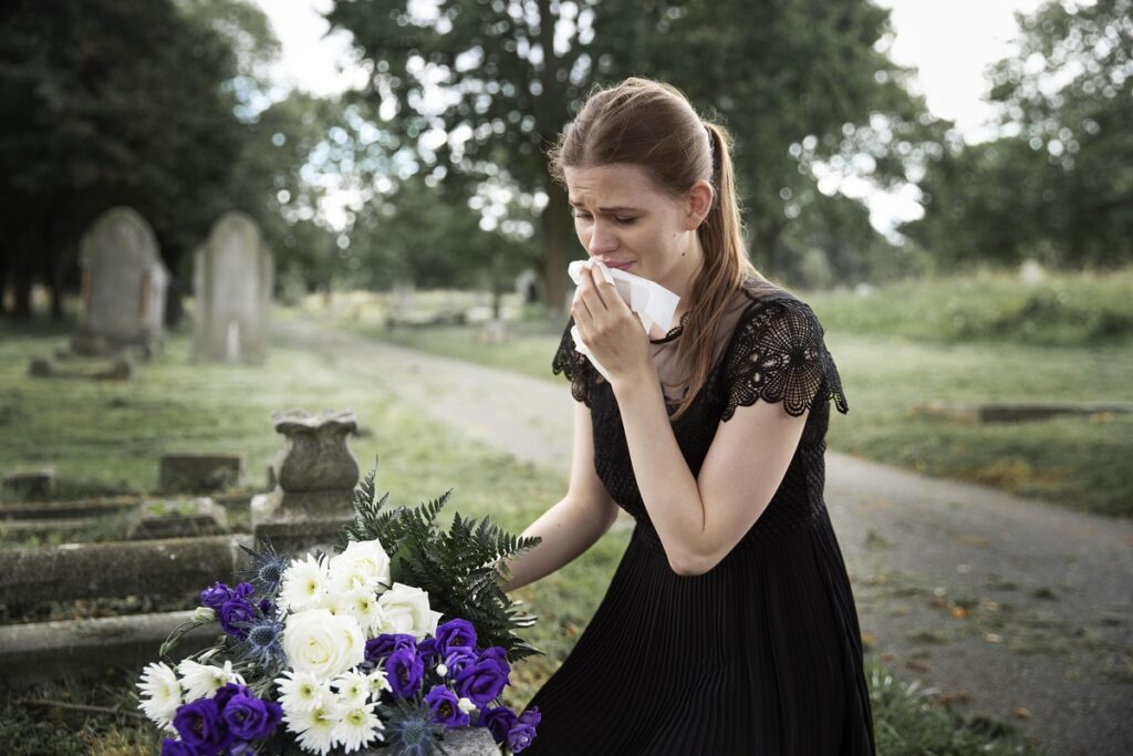 close up woman visiting grave loved one